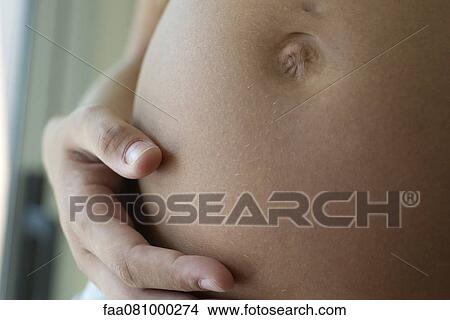 Pregnant woman's belly, close-up View Large Photo Image Picture - Pregnant woman's belly, close-up. Fotosearch