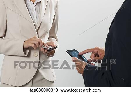 Professionals exhanging contact information on cell phones, cropped View Large Photo Image Stock Photo - Professionals exhanging contact information on cell phones, cropped. Fotosearch