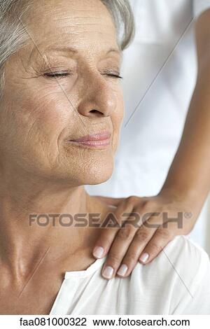 Stock Image - Senior woman getting a shoulder massage, cropped. Fotosearch