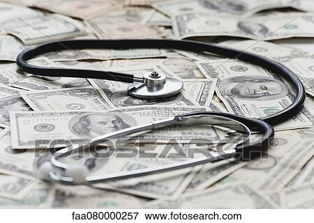 Stethscope on pile of US banknotes View Large Photo Image Stock Photo - Stethscope on pile of US banknotes. Fotosearch