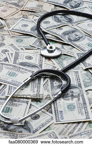Stethscope on pile of US banknotes View Large Photo Image Stock Photo - Stethscope on pile of US banknotes. Fotosearch