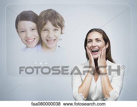 Woman doing video conference with children using advanced touch screen technology View Large Photo Image Stock Photo - Woman doing video conference with children using advanced touch screen technology. Fotosearch