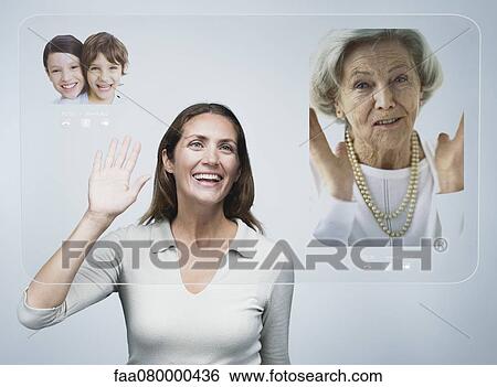 Woman doing video conference with family using advanced screen technology View Large Photo Image Stock Photograph - Woman doing video conference with family using advanced screen technology. Fotosearch