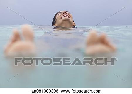 Stock Photograph - Woman floating in water. Fotosearch