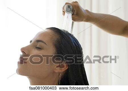 Stock Image - Woman having hair rinsed. Fotosearch