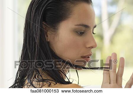 Woman looking at strand of hair, side view View Large Photo Image Stock Image - Woman looking at strand of hair, side view. Fotosearch