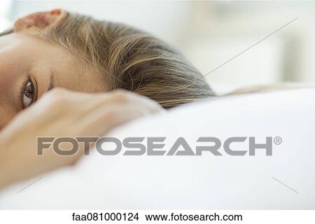 Woman lying down, looking at camera, cropped View Large Photo Image Picture - Woman lying down, looking at camera, cropped. Fotosearch