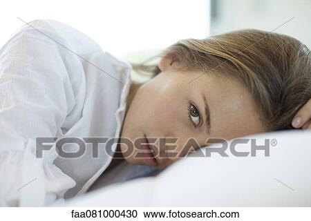 Stock Image - Woman lying down, portrait. Fotosearch