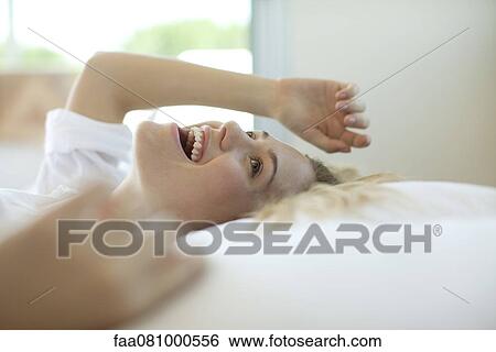 Woman lying on back, laughing View Large Photo Image Stock Photograph - Woman lying on back, laughing. Fotosearch