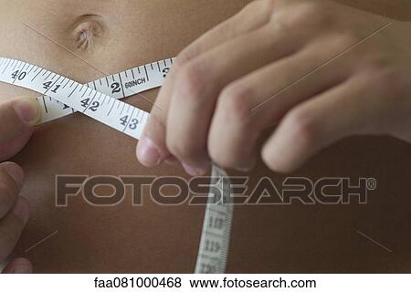 Woman measuring stomach, cropped View Large Photo Image Stock Photo - Woman measuring stomach, cropped. Fotosearch