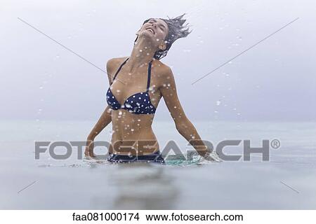 Picture - Woman splashing in water. Fotosearch