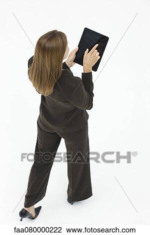 Woman using digital tablet while walking View Large Photo Image Stock Image - Woman using digital tablet while walking. Fotosearch