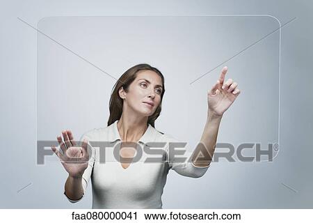 Woman using large transparent touch screen View Large Photo Image Stock Image - Woman using large transparent touch screen. Fotosearch