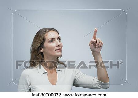Stock Image - Woman using large transparent touch screen. Fotosearch