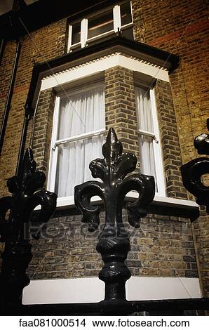 Picture - Wrought iron fence and bay window. Fotosearch