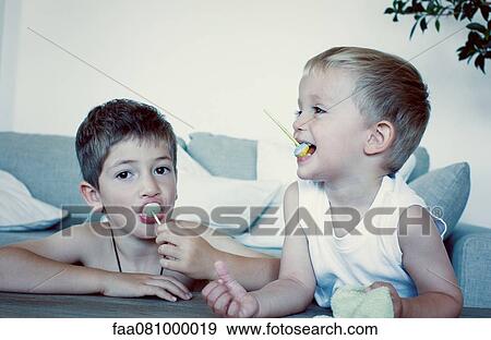 Young boys eating lollipops View Large Photo Image Stock Photo - Young boys eating lollipops. Fotosearch