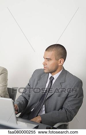 Young businessman using laptop computer View Large Photo Image Stock Photography - Young businessman using laptop computer. Fotosearch