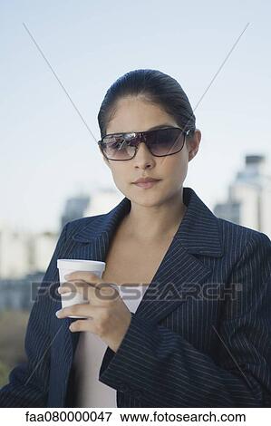Young businesswoman holding disposable cup View Large Photo Image Stock Photo - Young businesswoman holding disposable cup. Fotosearch