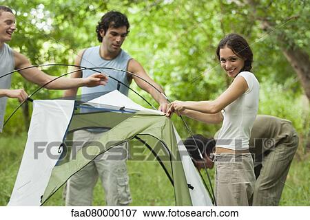Stock Photo - Young campers setting up tent. Fotosearch