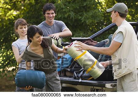 Stock Photography - Young campers unloading camping gear from back of pick-up truck. Fotosearch