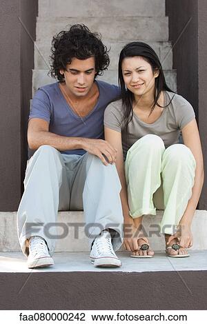 Stock Image - Young couple sitting together on steps. Fotosearch