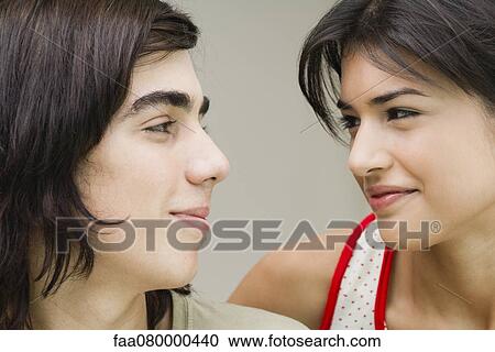 Stock Image - Young couple smiling at each other. Fotosearch