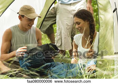 Young couple unrolling sleeping bag in tent View Large Photo Image Stock Photograph - Young couple unrolling sleeping bag in tent. Fotosearch