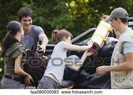 Young men helping young women loading camping gear onto back of pick-up truck View Large Photo Image Stock Image - Young men helping young women loading camping gear onto back of pick-up truck. Fotosearch