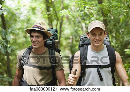 Stock Photo - Young men hiking in forest. Fotosearch