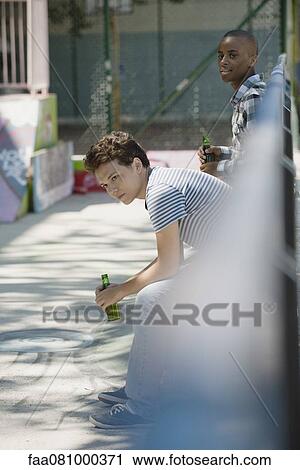 Young men holding beer bottles View Large Photo Image Stock Image - Young men holding beer bottles. Fotosearch