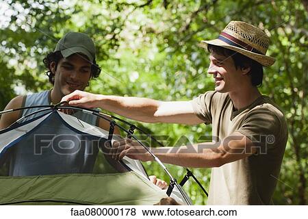 Young men setting up tent in woods View Large Photo Image Stock Photo - Young men setting up tent in woods. Fotosearch