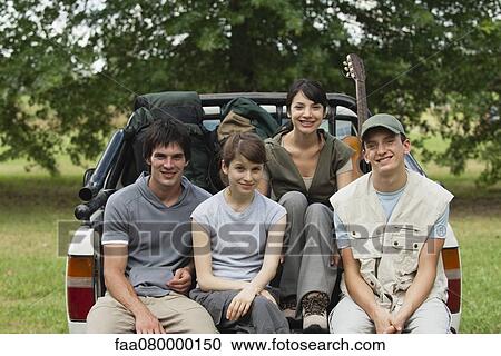 Young travelers sitting in back of pick-up truck, portrait View Large Photo Image Stock Image - Young travelers sitting in back of pick-up truck, portrait. Fotosearch