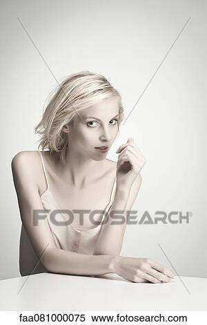 Stock Photography - Young woman at table, portrait. Fotosearch