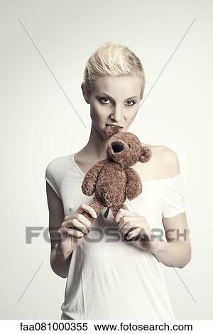 Young woman biting teddy bear, portrait View Large Photo Image Stock Photography - Young woman biting teddy bear, portrait. Fotosearch