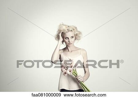 Young woman holding bunch of gerbera daisies, portrait View Large Photo Image Stock Photo - Young woman holding bunch of gerbera daisies, portrait. Fotosearch