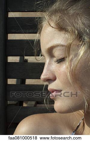 Stock Photo - Young woman in profile, eyes closed, portrait. Fotosearch