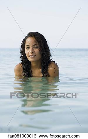 Stock Image - Young woman in water, portrait. Fotosearch