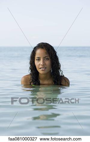 Stock Photo - Young woman in water, portrait. Fotosearch