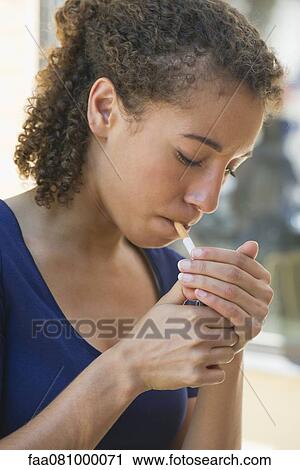 Young woman lighting cigarette View Large Photo Image Stock Image - Young woman lighting cigarette. Fotosearch