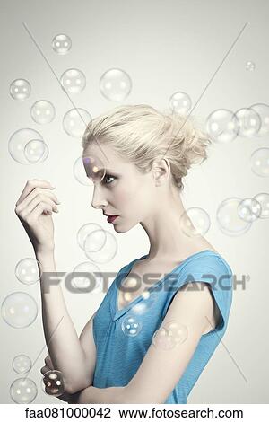 Young woman surrounded by bubbles, portrait View Large Photo Image Stock Image - Young woman surrounded by bubbles, portrait. Fotosearch