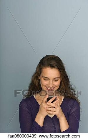 Young woman text messaging with cell phone, portrait View Large Photo Image Stock Photo - Young woman text messaging with cell phone, portrait. Fotosearch