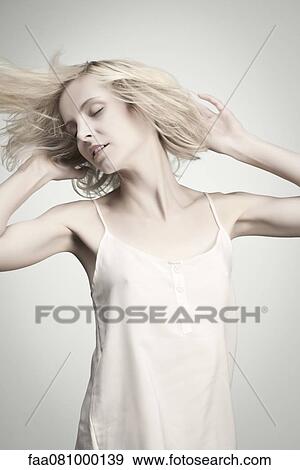 Young woman tossing hair with eyes closed, portrait View Large Photo Image Stock Photo - Young woman tossing hair with eyes closed, portrait. Fotosearch