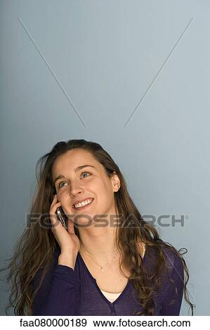 Stock Photo - Young woman using cell phone, portrait. Fotosearch