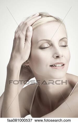 Stock Photo - Young woman with eyes closed, portrait. Fotosearch