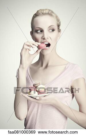 Young woman with plate of macaroons, portrait View Large Photo Image Stock Photo - Young woman with plate of macaroons, portrait. Fotosearch