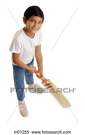 Stock Photography - Boy holding cricket bat, smiling at camera. Fotosearch
