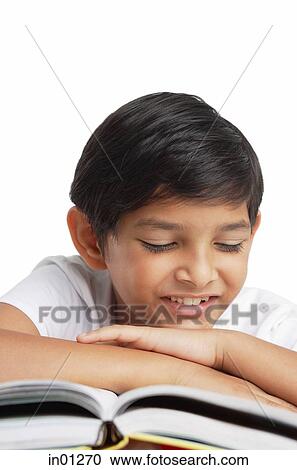 Boy leaning head on hand, looking at book View Large Photo Image Stock Image - Boy leaning head on hand, looking at book. Fotosearch