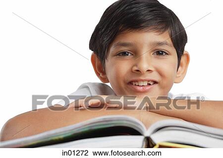 Boy leaning on book, looking at camera View Large Photo Image Stock Image - Boy leaning on book, looking at camera. Fotosearch
