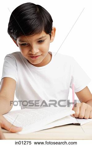 Boy looking at book and writing View Large Photo Image Stock Photography - Boy looking at book and writing. Fotosearch