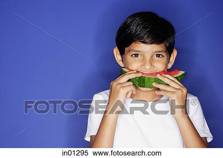 Stock Photography - Boy looking at camera, eating watermelon. Fotosearch